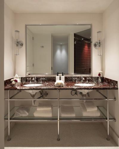a bathroom with two sinks and a large mirror at El Cortés, Member of Relais & Châteaux in Mexico City