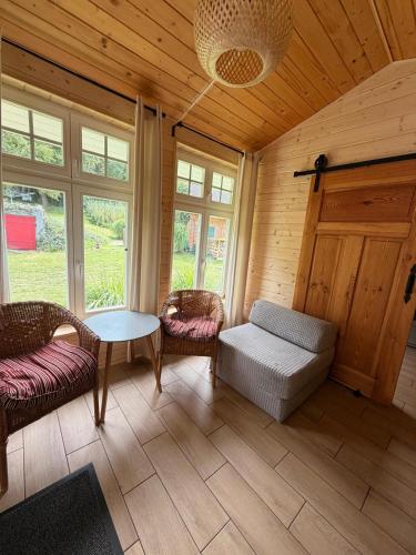 a living room with a couch and chairs and a table at Leśne Doliny 38 in Zwiartów