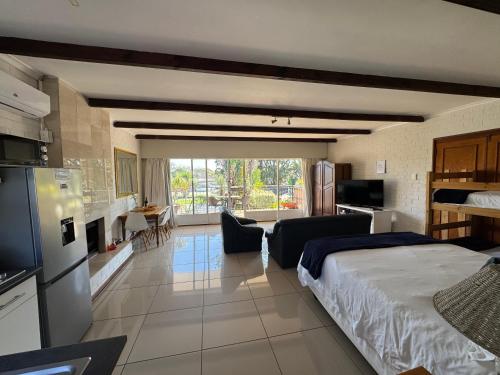 a bedroom with a bed and a kitchen and a living room at Eagles Rest Guest House in Summerstrand