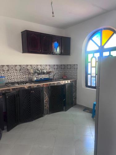 a kitchen with a sink and a stained glass window at Villa compagne sans vis-à-vis in Ounara