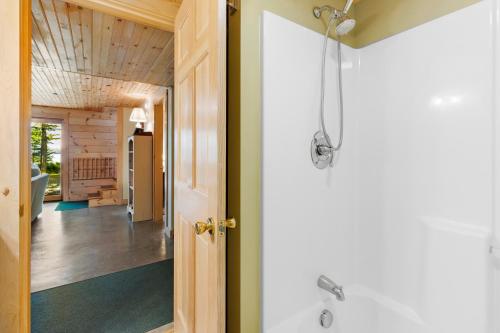 a bathroom with a shower and a hallway at Waterfront cabin w/ outdoor firepit, dock, and lake views - dogs welcome in Greenville