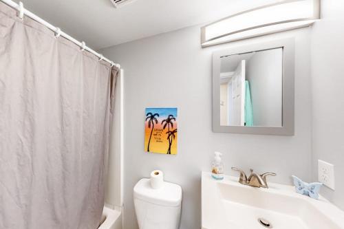 a bathroom with a toilet and a sink and a mirror at Montego Bay - Atlantic 13300 in Ocean City
