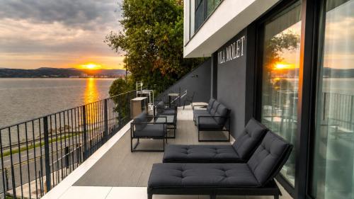 a balcony with couches and a view of the water at VILA MOLET KOPER in Koper