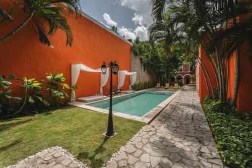 an orange building with a swimming pool next to a house at Casa Jade Hotel - Adults Only, Mérida in Mérida