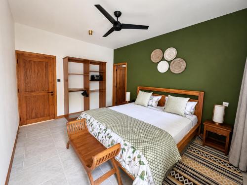 a bedroom with a large bed and a ceiling fan at Sea Esta in Le Morne