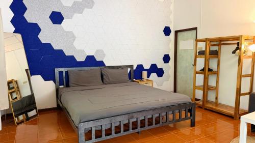 a bedroom with a bed with a blue and white wall at Zen Forest in Ko Phangan