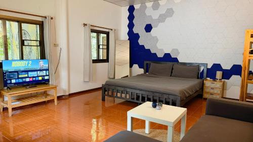 a living room with a bed and a tv at Zen Forest in Ko Phangan