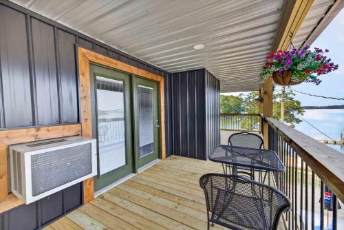 a tiny house with a balcony with a tv and chairs at Little River Marina in Cedar Bluff