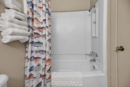 a bathroom with a shower curtain with fish on it at Little River Marina in Cedar Bluff