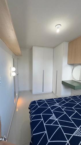 a room with a blue and white bed and cabinets at Flat Eufrates 205 in Olinda