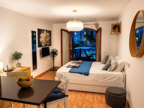 a bedroom with a bed and a table and a desk at STUDIO TAGORO in Costa Del Silencio