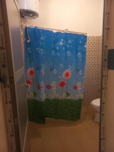 a bathroom with a shower curtain with an aquarium at Chez ABDOUL in Rufisque