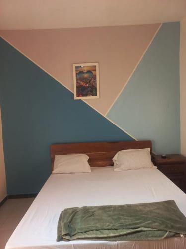 a bedroom with a large white bed with at Chez ABDOUL in Rufisque