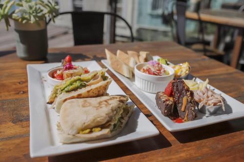 a table with two plates with sandwiches and dips at Hotel Boutique 17 in Valparaíso