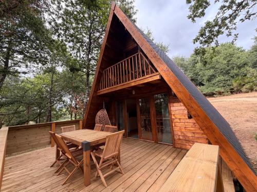 a cabin with a table and chairs on a deck at KOADOu in Pluméliau
