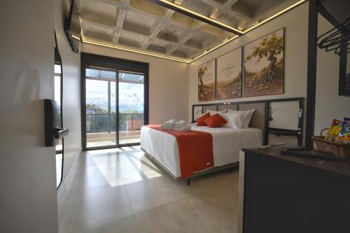 a bedroom with a bed with orange pillows on it at Pousada Premium Terragnolo in Bento Gonçalves