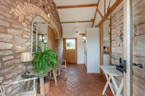a living room with a stone wall and a table at 1 Bed in Bristol oc-85559 in Langford