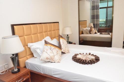 a bedroom with a large white bed with a headboard at Nefaland Hotel in Dar es Salaam