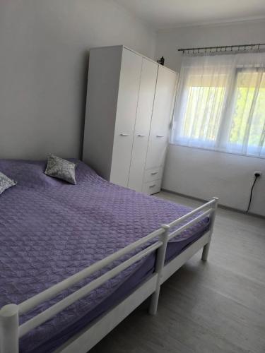 a bedroom with a purple bed and a white cabinet at Oaza Slankamen in Slankamenački Vinogradi