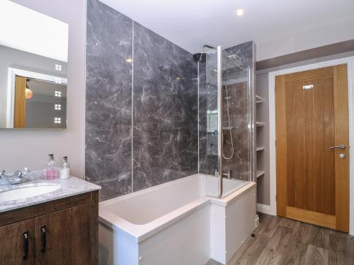 a bathroom with a shower and a tub and a sink at 19 Lion Street in Hereford