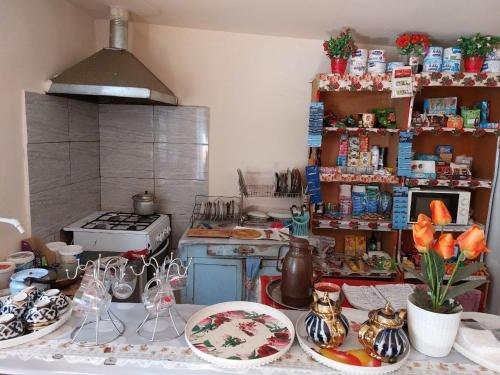 a kitchen with a table with plates and dishes at Umid Hostel in Termiz