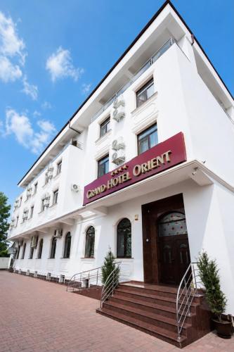 ein weißes Gebäude mit einem Schild, auf dem „Grand Hotel Orient“ steht in der Unterkunft Grand Hotel Orient Braila in Brăila