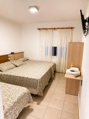 a hotel room with two beds and a window at Hotel Diamante in Resistencia