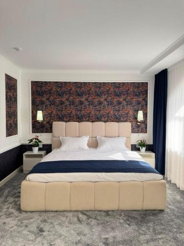 a bedroom with a large bed with a large headboard at K41House in Almaty