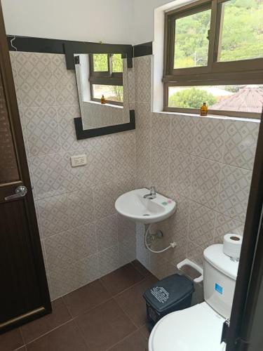 a bathroom with a sink and a toilet and a mirror at Naru CasaBlanca in Utica