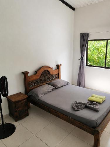 a bedroom with a bed with a wooden headboard and a window at Naru CasaBlanca in Utica