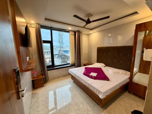 ein Schlafzimmer mit einem Bett, auf dem ein rotes Handtuch liegt in der Unterkunft Hotel A1 Star in Ajmer