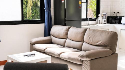 a brown couch in a living room with a table at Zen Nest in Ko Phangan