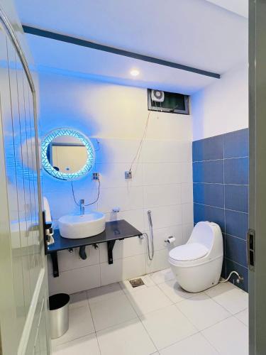 a bathroom with a toilet and a sink and a mirror at Stay O'clock Hotel Skardu in Skardu