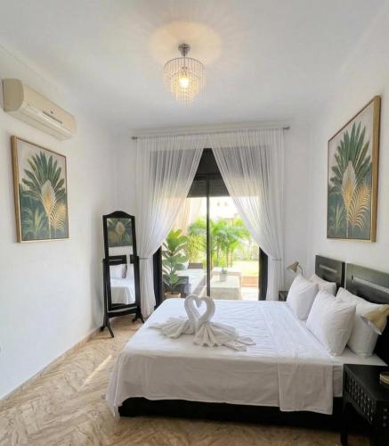 a bedroom with a large white bed with a window at atlas golf resort in Marrakesh
