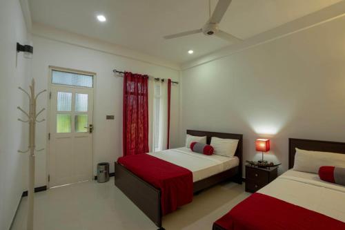 a bedroom with two beds and a window at My Home Guest in Polonnaruwa