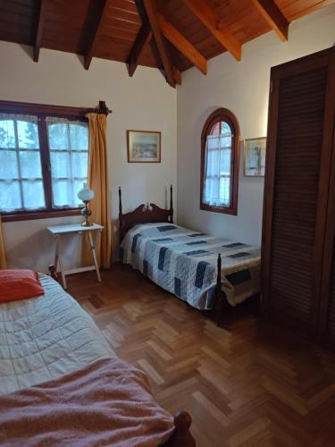 a bedroom with two beds and a desk and windows at Lo de Delia in City Bell