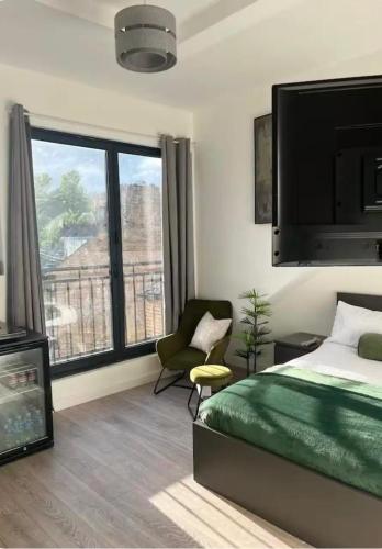 a bedroom with a bed and a chair and a large window at Encliffe apartment in Nether Edge