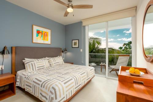 a bedroom with a bed and a balcony at Luxurious penthouse by the beach in Akumal