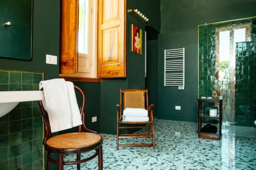 a green bathroom with two chairs and a shower at Villa Ceci Dimora di Storie in Andria