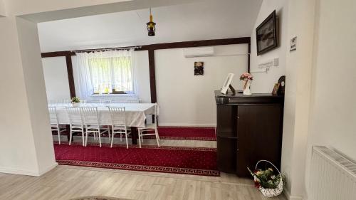 a dining room with a white table and a window at Villa Odorica in Gura Humorului