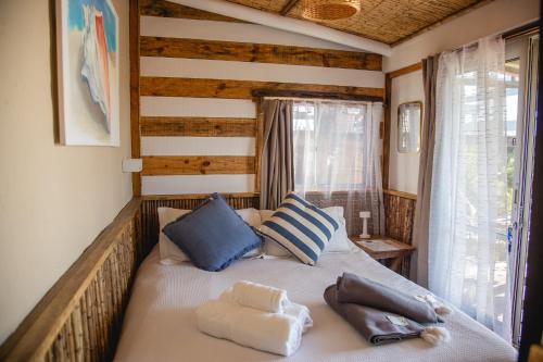 a bedroom with a bed with blue and white pillows at Carmela Suites Cabo Polonio in Cabo Polonio