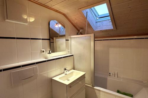 a bathroom with a sink and a mirror and a window at Apartment in the Upper Bavarian Alps in Bad Kohlgrub