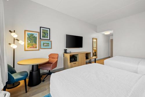 a hotel room with a bed and a table and a tv at Hampton Inn and Suites Swansboro Near Camp Lejeune in Swansboro