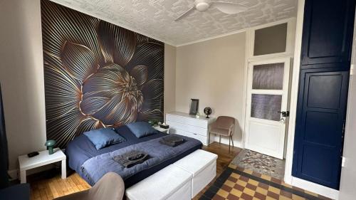 a bedroom with a blue bed with a large flower mural at Maison Diderot in Langres