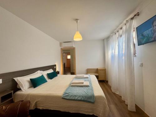 a bedroom with a large bed with blue pillows at Alojamentos do Conde in Ponte de Lima