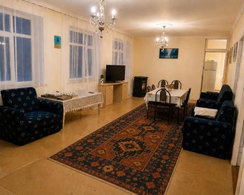 a living room with a couch and a table and chairs at GreenHouse in Qusar