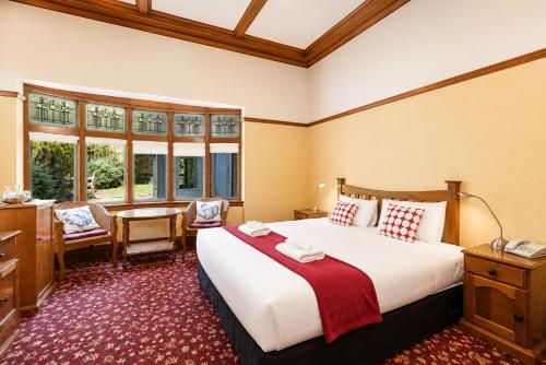 a hotel room with a large bed and a desk at Halswell Lodge in Wellington