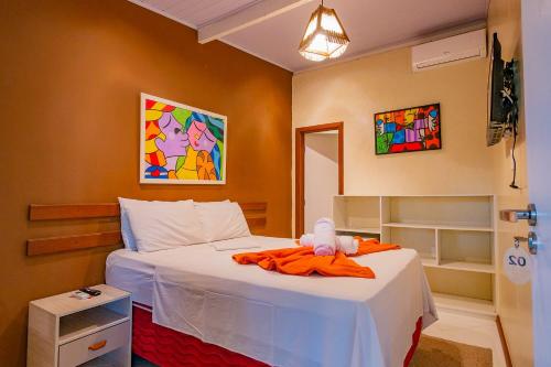 a bedroom with a bed with a stuffed animal on it at Pousada Ilha do Meio in Itacimirim