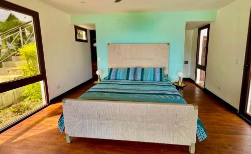 a bedroom with a large bed with blue walls at Bliss Resort in San Juan del Sur