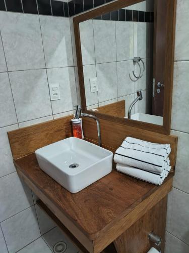 a bathroom with a white sink and a mirror at Porto Zarpa Hotel in Praia do Forte